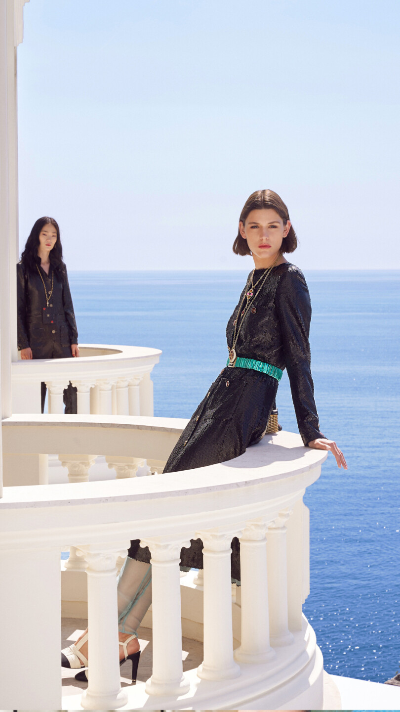 Un balcon sur la mer de la villa La Vigie, où les modèles de Chanel prennent la pose en robes brodées et pailletées de la collection Croisière 2022-2023.